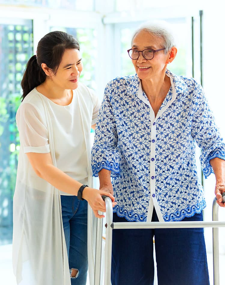 caregiver helping her patient on a walker