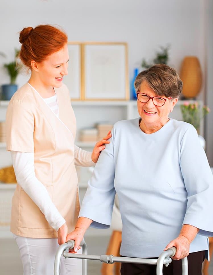 caregiver and her patient on a walker having a laugh