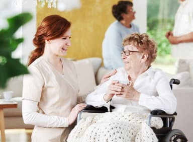 caregiver chatting with her patient on a wheel chair