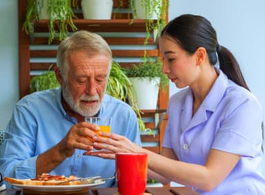 caregiver giving her patient a drink