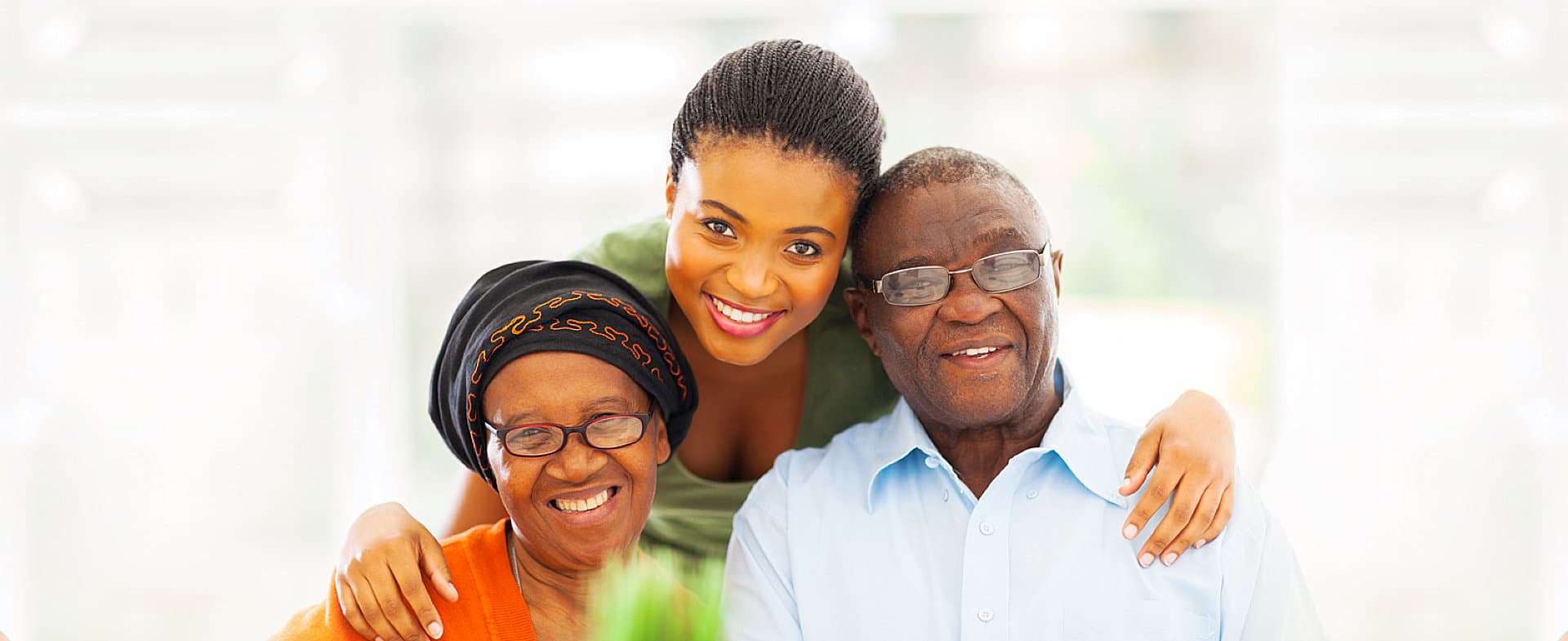 caregiver and a couple smiling at the camera