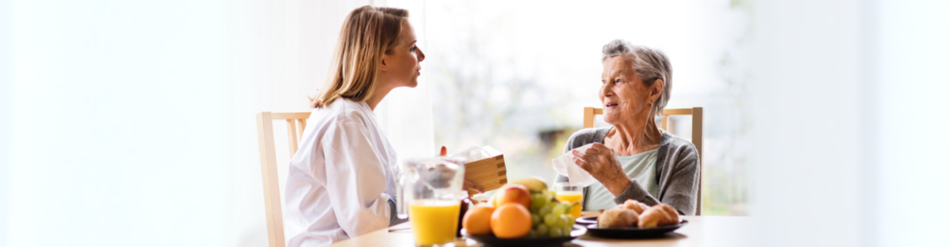 physicians talking to senior woman with healthy foods in the table