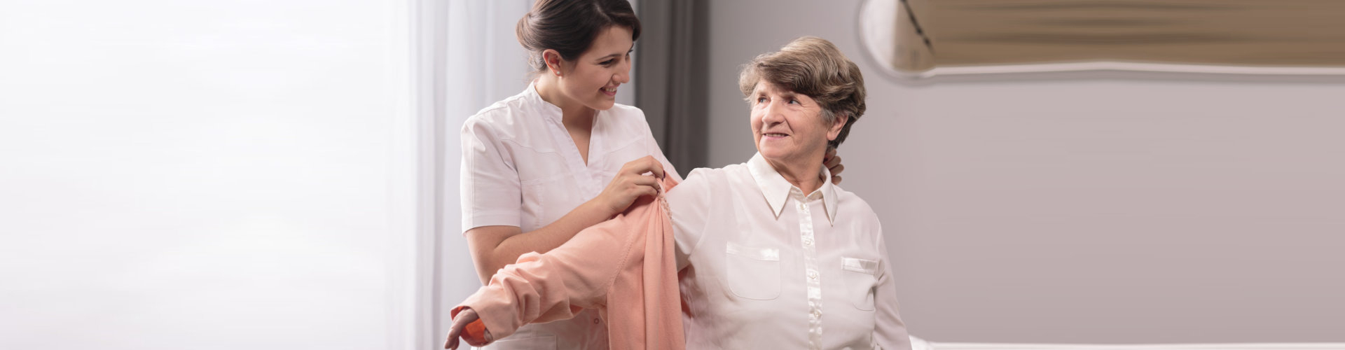 caregiver helping the patient with her clothes